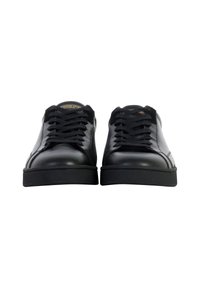 Sneaker in pelle nera con superficie liscia, punta tonda e lacci piatti, suola in gomma nera testurizzata e con un discreto marchio sulla linguetta.