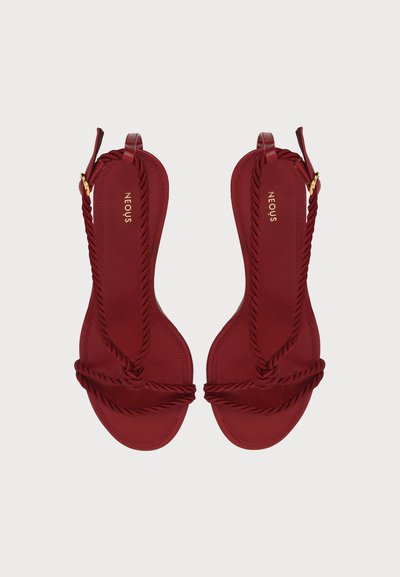 Paire de sandales plates bordeaux avec brides en corde torsadée, boucles dorées et logo "NEOUS" sur les semelles intérieures, vues de dessus.