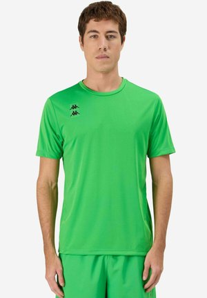 Homme portant un maillot de sport à manches courtes vert vif et un short assorti, debout de face sur un fond blanc.