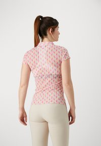 Kortermet rosa topp med teksturert geometrisk mønster. Har slim fit og krage, laget av lett stoff med en glatt finish.
