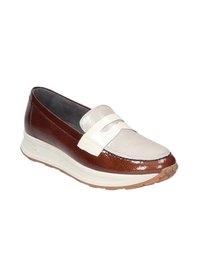 Zapato de deslizamiento de cuero marrón y crema con un empeine texturizado, acentos suaves y una suela blanca chunky. Presenta un diseño minimalista de tiras.