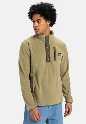 Olive green fleece pullover with a high collar, snap button placket, side pockets, and contrasting dark green accents. Soft texture.