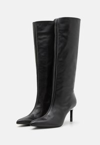 Knelang svarte skinnstøvler med spiss tå og tynn stilett hæl, med en glatt tekstur og tettsittende silhuett.