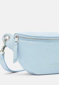 Borsa in pelle celeste chiaro a forma arrotondata, con zip silver e tracolla regolabile. Presenta un dettaglio del nome del brand embossato.