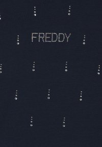 Maglietta blu navy con la parola "FREDDY" in strass, circondata da piccoli strass disposti in linee verticali sul tessuto.