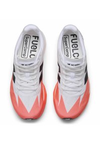 Zapatillas deportivas blancas con una parte superior texturizada, detalles en negro y una suela exterior color coral brillante con un patrón en zigzag. Marca en la plantilla.