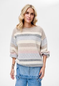 Sweter dziergany w kolorze beżowym z poziomymi paskami w odcieniach szarości, jasnoniebieskiego i delikatnego różu. Posiada szeroki, okrągły dekolt oraz podwinięte rękawy.