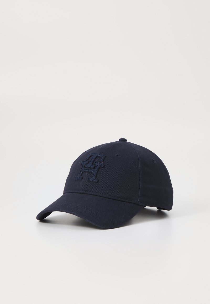 Navy blue baseball cap with a stitched emblem on the front. Features a curved brim and adjustable strap at the back. Classic design.