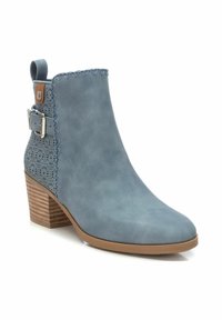Bottine bleue en daim lisse avec un talon en bois évasé, des perforations décoratives sur le côté et une boucle réglable.