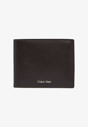 Donkerbruine leren portemonnee met zichtbare stiksels en klein zilveren Calvin Klein-logo aan de voorkant in het midden tegen een witte achtergrond.
