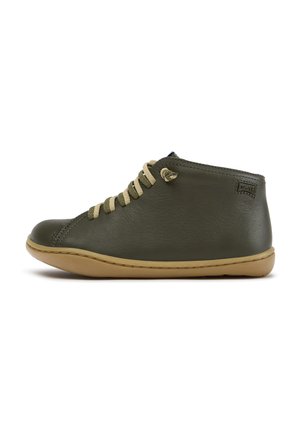 Chaussure basse en cuir vert olive avec des lacets beiges et une semelle en caoutchouc marron clair, vue de côté extérieur.