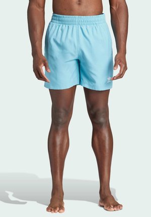 Shorts da bagno leggeri blu chiaro con vita elastica, design semplice e un piccolo logo bianco sulla coscia sinistra. Realizzati in tessuto leggero.