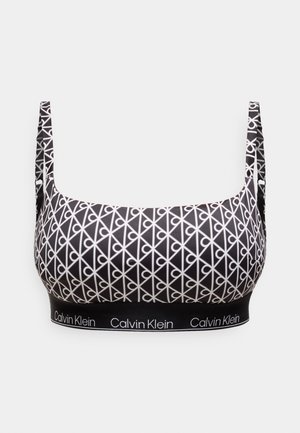Αθλητικό σουτιέν Calvin Klein σε ασπρόμαυρο με γεωμετρικό μοτίβο και ελαστική ταινία με λογότυπο κάτω από το στήθος.