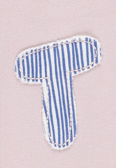 Un tessuto rosa con una applicazione a forma di "T" a strisce blu e bianche, rifinito con cuciture bianche, crea un contrasto testurizzato su uno sfondo liscio.