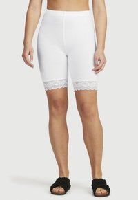 Witte katoen shorts met een rekbare tailleband en kant aan de onderrand. Het kant heeft een bloemmotief en een gegolfde rand.