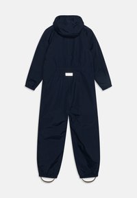Navy blue one-piece jumpsuit with a hood, elastic cuffs, gathered waist, and adjustable loop accents at the ankles, made from a water-resistant material.