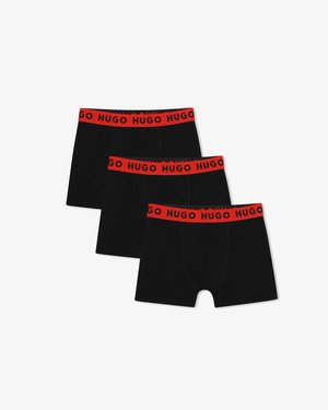 Tre boxer aderenti neri con fascia in vita rossa con la scritta "HUGO" in nero, disposti in uno stile piatto e sovrapposto, con messa a fuoco.