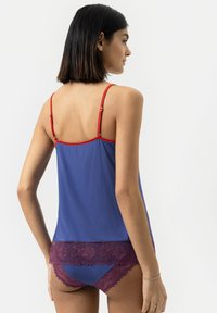 Niebieska bluzka na ramiączkach z czerwonymi akcentami i regulowanymi ramiączkami, połączona z burgundowymi majtkami wykończonymi koronką. Gładka tekstura, casualowy design.