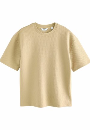 Beige kortärmad t-shirt gjord av texturerat tyg med ett diskret diamantmönster. Rund halsringning och avslappnad passform.