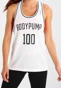 Biała siatkowa koszulka bez rękawów z czarnym napisem "BODYPUMP 100", okrągłym dekoltem z kontrastowym wykończeniem i luźnym krojem.