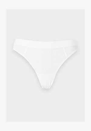 Λευκό γυναικείο εσώρουχο τύπου στρινγκ από ριμπ ύφασμα με ελαστική μέση, απλωμένο σε φωτεινό φόντο.