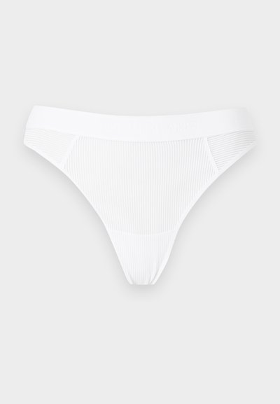 String femme en tissu côtelé blanc avec taille élastique, présenté à plat sur un fond clair.