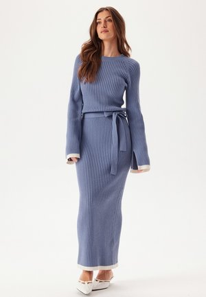 Rippstrickkleid in Hellblau, mit langen Ärmeln, einem taillierten Gürtel und kontrastierenden weißen Manschetten, in taillierter Silhouette.