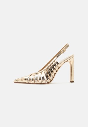 Arany fémes magas sarkú slingback cipő hegyes orral és szőtt pántos kialakítással fehér háttéren.