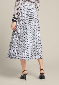 Plissé midi rok in een blauw-wit geometrisch patroon, gemaakt van lichtgewicht stof. Heeft een aansluitende taille en een vloeiende silhouet.