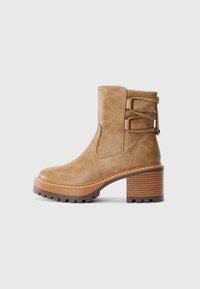 Braune Knöchelstiefel aus strukturiertem Kunstleder, mit einem dicken, gestreiften Absatz und dekorativen seitlichen Riemen für zusätzlichen Stil.