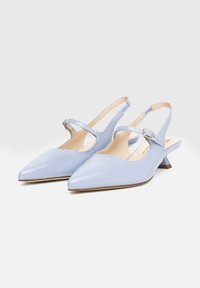 Chaussures slingback en cuir verni bleu clair avec un bout pointu et un petit talon. Comprend une lanière ajustable à la cheville et des côtés découpés.