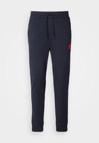 Navy joggingbroek gemaakt van een katoenen mix, met een elastische tailleband met trekkoord, zijzak en een rood merklogo op de dij.