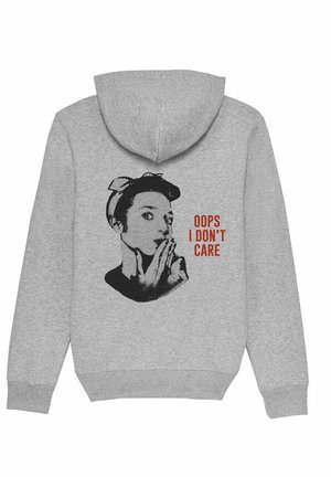 Sweat à capuche gris avec un graphisme noir représentant une femme portant sa main à sa bouche et un texte rouge indiquant "OOPS I DON'T CARE."