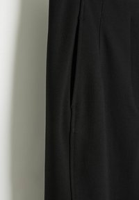 Czarne spodnie z gładką fakturą materiału, z boczną kieszenią i dopasowanym krojem. W projekcie znajduje się subtelny detal w postaci zaszewki.