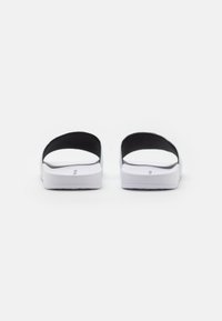 Infradito neri con due ampie cinghie, parte superiore testurizzata e suola in gomma bianca. Il design è minimalista, senza ulteriori decorazioni.