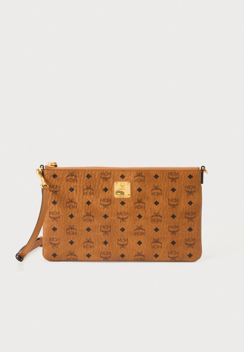 Bracelet en cuir marron avec motif logo MCM noir et plaque métallique dorée, avec fermeture éclair et sangle amovible sur fond blanc.