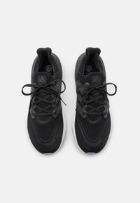 Scarpe sportive nere con tomaia in rete, punta rotonda e suola bianca a contrasto. Presentano lacci e logo del brand sul lato.