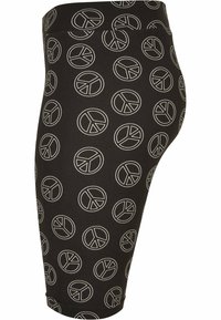 Fekete leggings fehér békejel mintával, testhezálló fazonnal, rugalmas derékpánttal és sima textúrával. Középmagas vádli hosszúságú kialakítás.