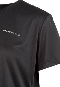 Schwarzes Sport-T-Shirt aus glattem, leichtem Stoff. Mit Rundhalsausschnitt, kurzen Ärmeln und dem Wort "ENDURANCE" in Weiß auf der Brust.