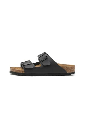 Sandalo Birkenstock nero con due cinturini regolabili con fibbie, sottopiede in sughero e suola nera texturizzata, mostrato di profilo.