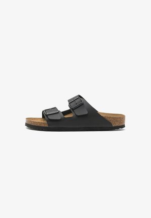Sandalo Birkenstock nero con due cinturini regolabili con fibbie, sottopiede in sughero e suola nera texturizzata, mostrato di profilo.