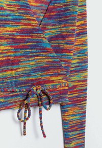Close-up van een meerkleurige gebreide sweater met rode, gele, blauwe en paarse draden, met een getrokken koord aan de onderrand.