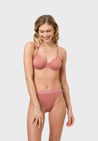 Helles pinkes Lingerie-Set aus glattem Material; beinhaltet einen formenden BH mit verstellbaren Trägern und passende hochgeschnittene Slips.