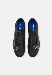 Scarpe da calcio nere in materiale sintetico testurizzato, dotate di un logo bianco curvo, suole interne blu e lacci neri.