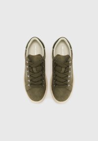 Olive green suede sneakers with thick khaki laces, metal eyelets, and a contrasting beige rubber sole. Rounded toe design.