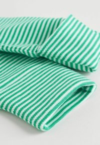 Zeleno-biele pruhované pletené rukávy, starostlivo zložené na bielom povrchu.