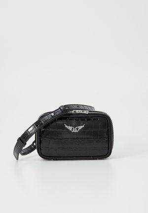 Sac noir à motif crocodile avec une fermeture éclair, présentant un design d'ailes clouté sur le devant et une sangle ajustable.