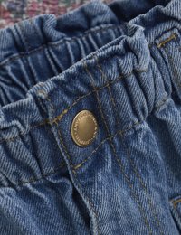 Jeansshorts med elastiskt midjeband, med en guldig metallknapp, synlig sömnad och en blå textur.