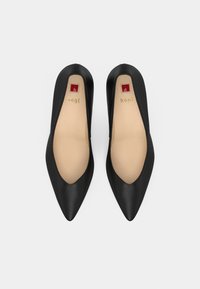 Svarta spetsiga ballerinas i slät läder, med en låg skärning och beige innersulor. Guldlogotyp på innersulan.