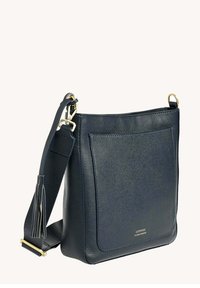 Sac en bandoulière en cuir marine avec une finition texturée, comprenant une poche avant, des accents en métal doré et une bandoulière détachable avec un pompon.